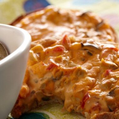 English muffin spread with cashew cheese and veggies baked until crisp