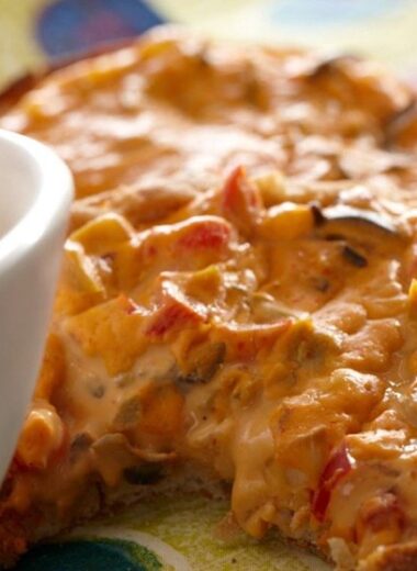 English muffin spread with cashew cheese and veggies baked until crisp