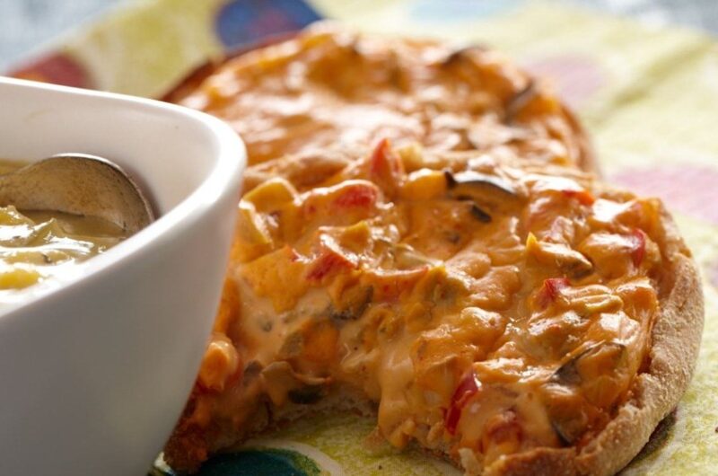 English muffin spread with cashew cheese and veggies baked until crisp